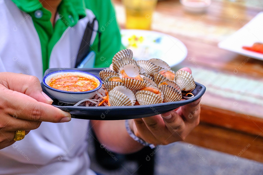 Mãos de pessoa segurando prato de comida