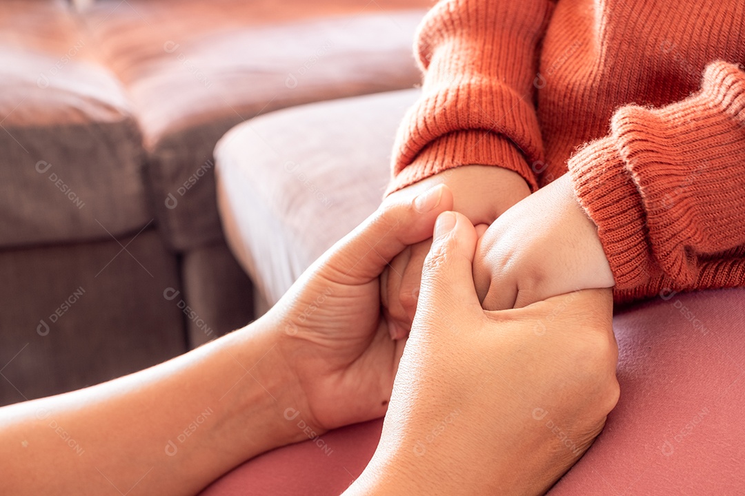 Mãe segurando a mão do bebê em casa para encorajar e esperar, conceito de família feliz