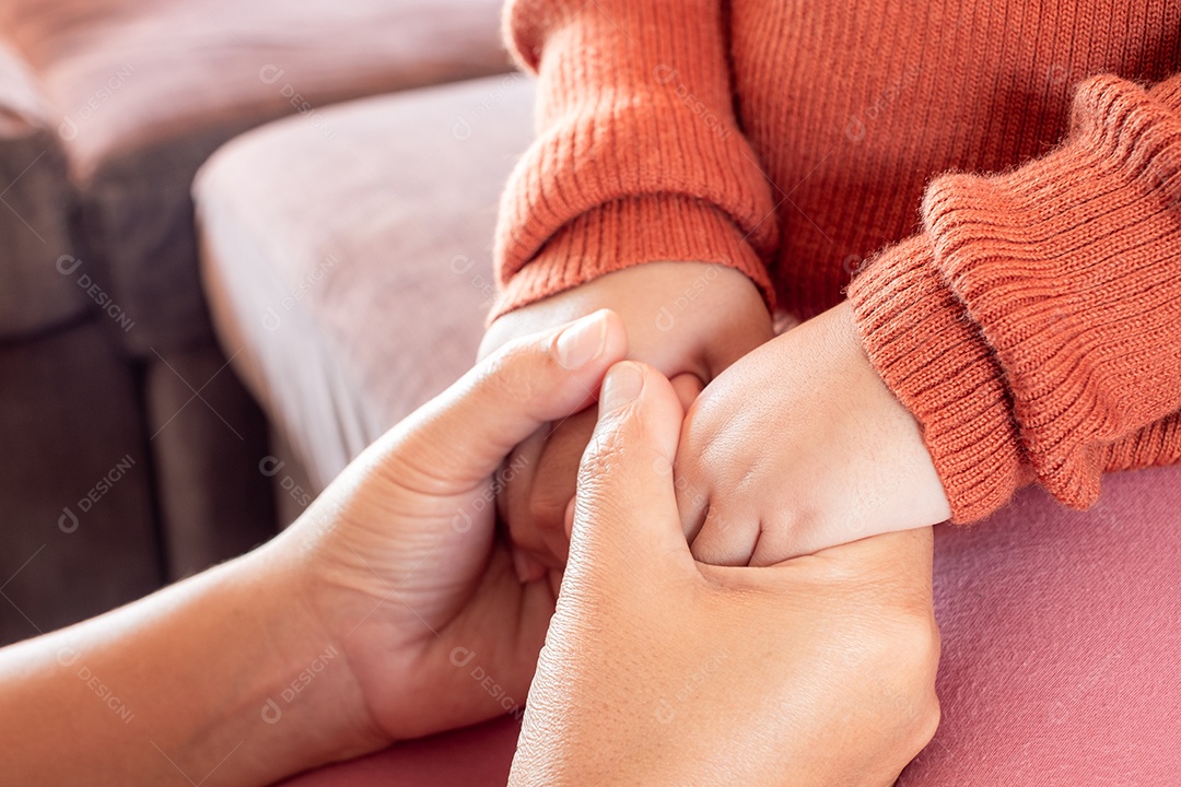 Mãe segurando a mão do bebê em casa para encorajar e esperar, conceito de família feliz