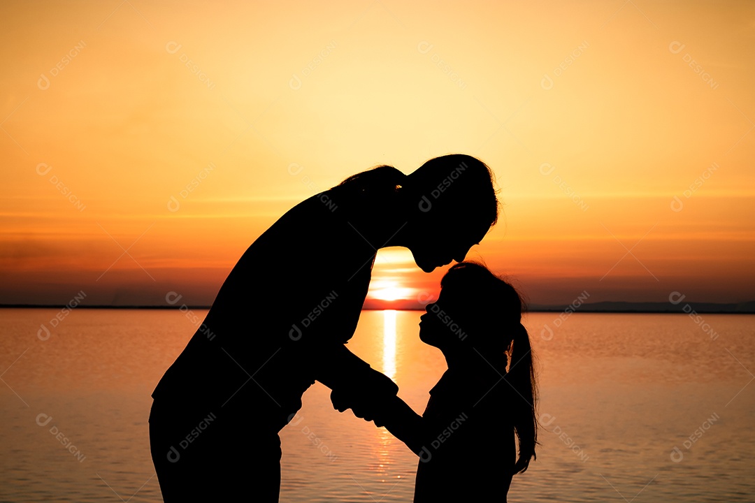 Silhueta de beijo de mãe para criança na natureza pôr do sol fundo, conceito de família feliz