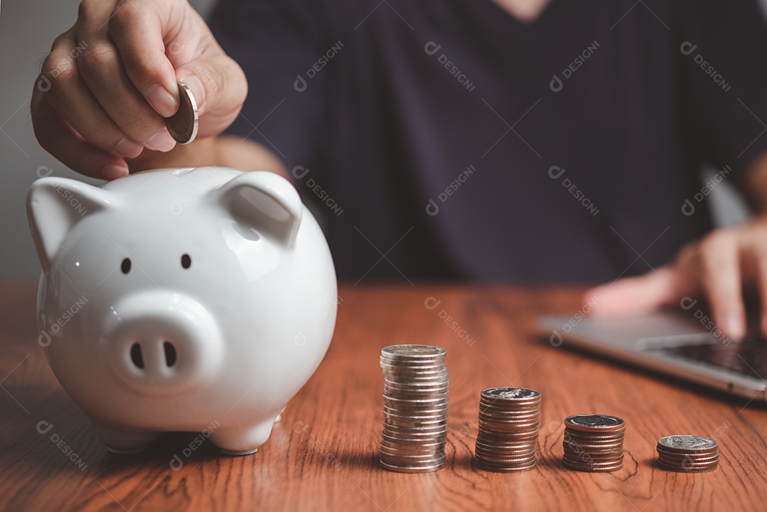 Empresário economizando dinheiro e moedas empilhando na mesa com nota para planejar o conceito de finanças de dinheiro. Investimento financeiro empresarial e fiscal, contabilidade.