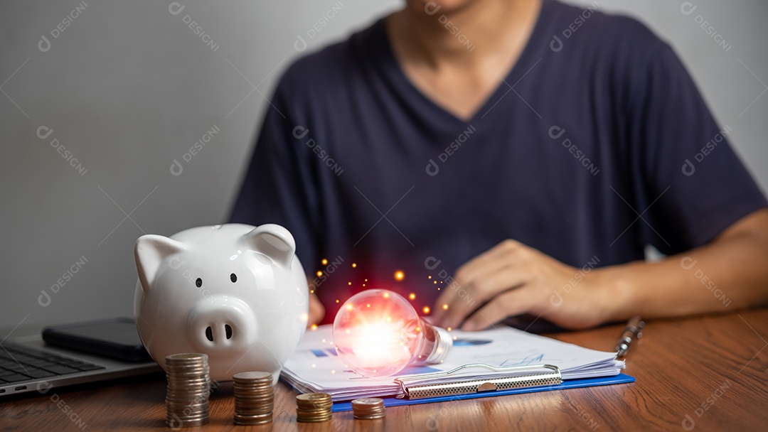 Lâmpada de negócios e cofrinho no documento representam a mesa para economia de energia e conceito de dinheiro bancário na mesa.