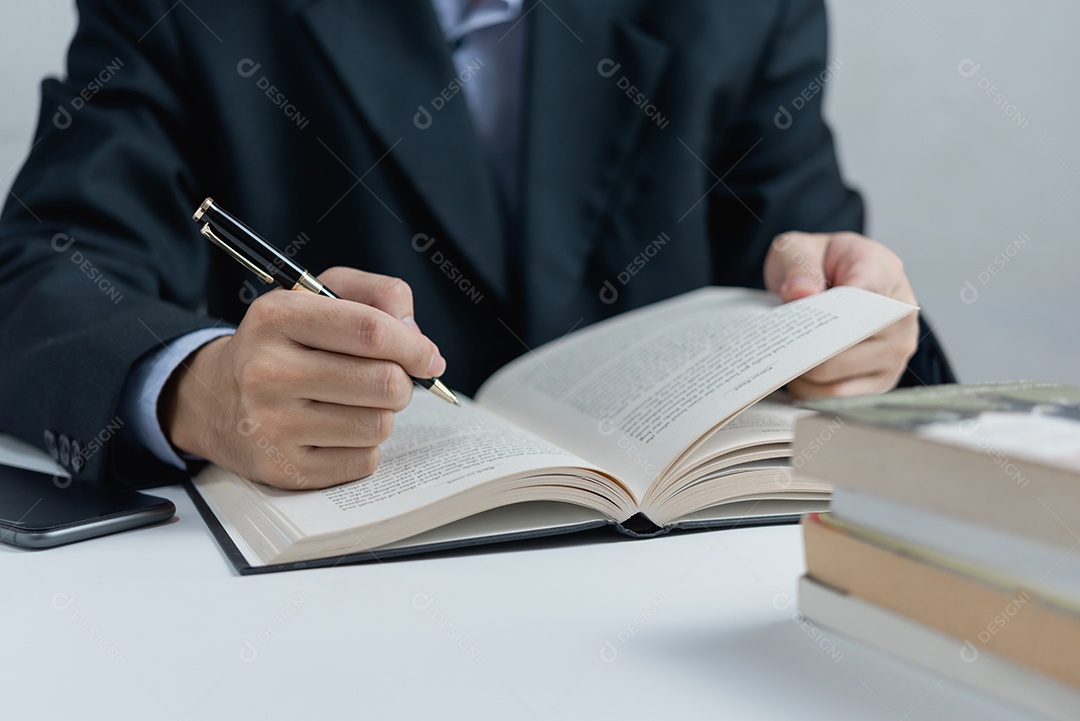 Empresário lendo e escrevendo sobre book.education estudando desenvolvimento de conhecimento e conceito de aprendizagem de cognição.