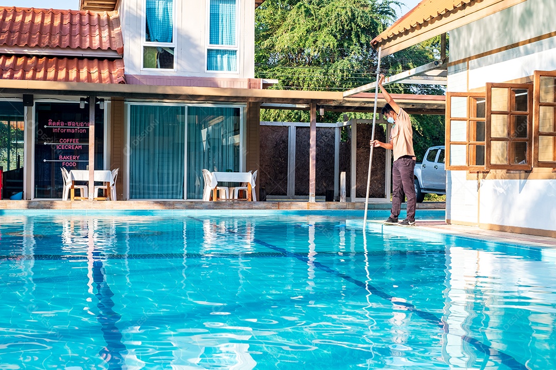 Piscineiro limpando a piscina