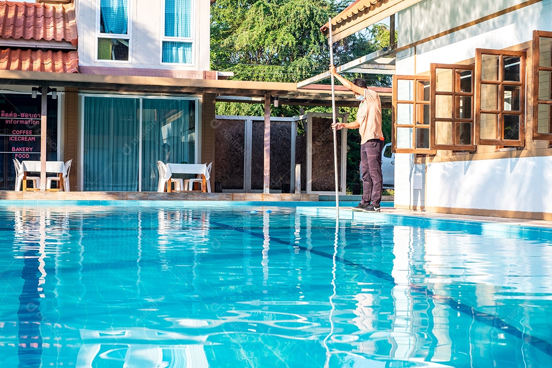 Piscineiro limpando a piscina