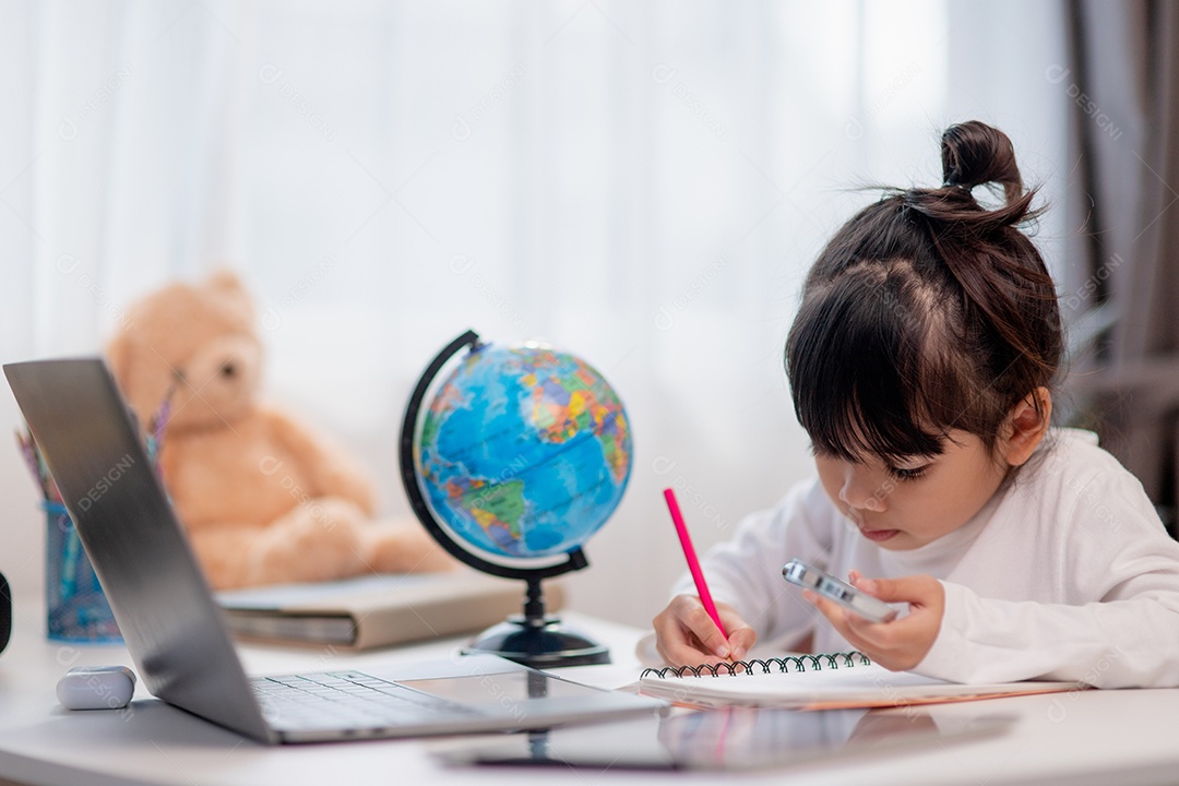 Aluna asiática fazendo sua lição de casa com o laptop em casa. As crianças usam aparelhos para estudar. Educação e ensino a distância para crianças. Educação domiciliar durante a quarentena. Ficar em casa