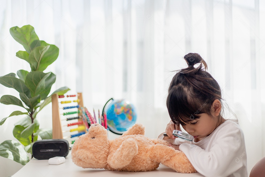 Criança brincando com ursinho de pelúcia. Menina asiática abraçando seu brinquedo favorito. Criança e bicho de pelúcia em casa.