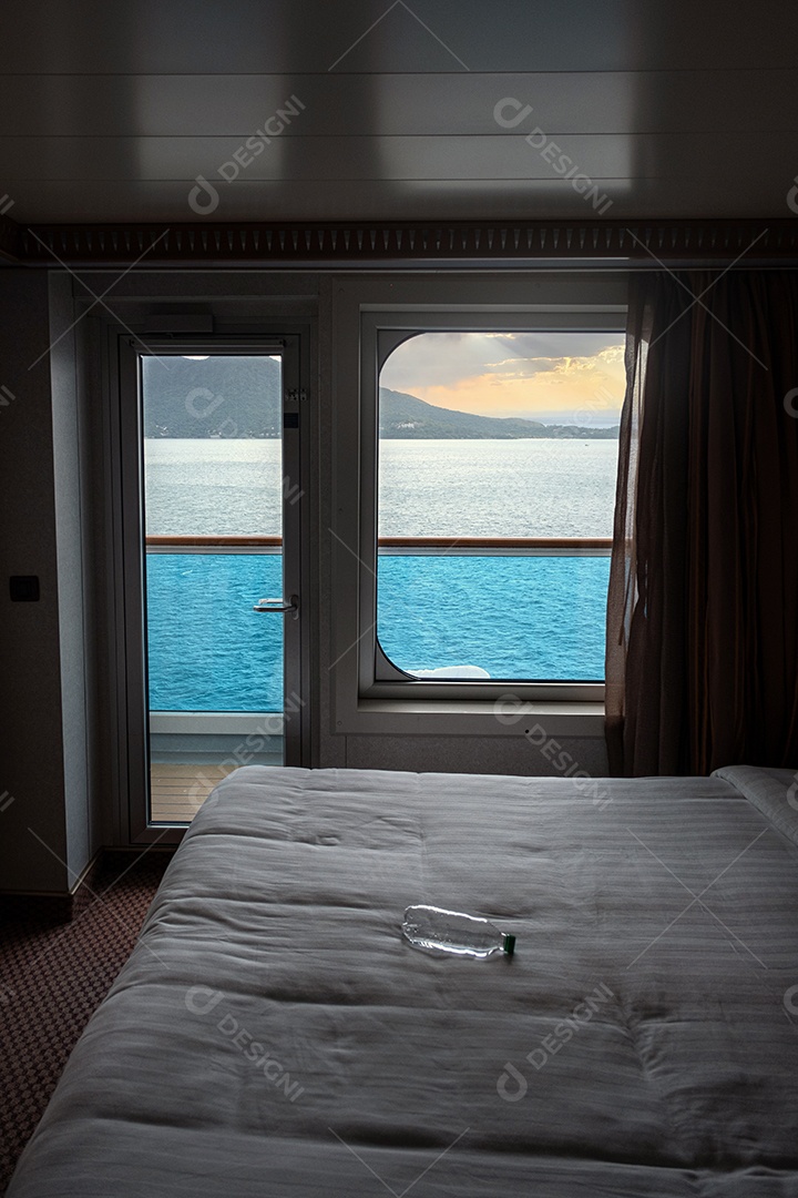 Garrafa de água na cama iluminada pela luz da cabine do cruzeiro