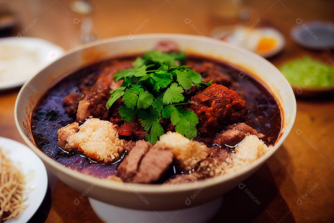Feijoada sobre uma mesa de madeira com acompanhamentos.