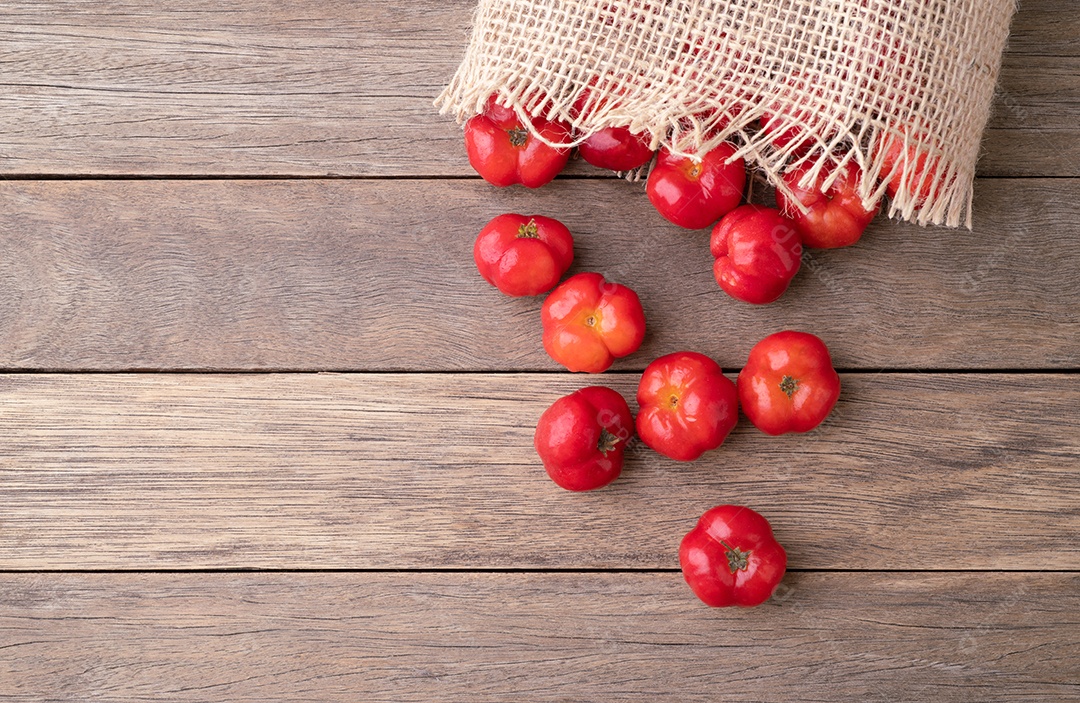 Acerolas ou cerejas de Barbados em uma tigela sobre a mesa de madeira.
