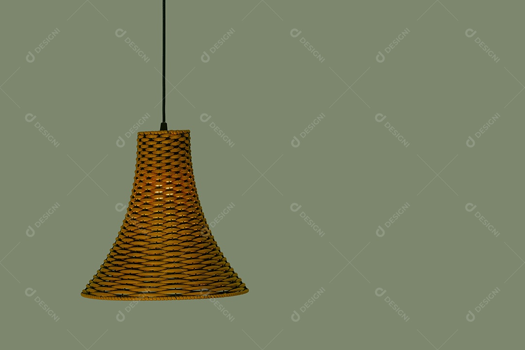Lustre de sisal com luz acesa com parede verde ao fundo.