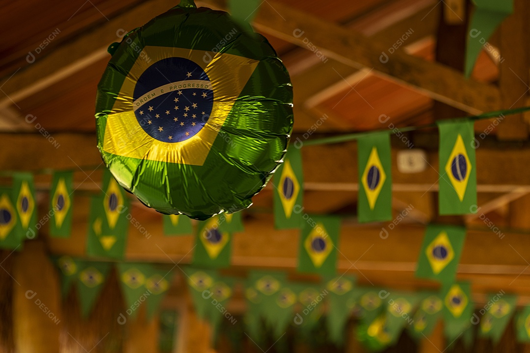 balãozinho e bandeirinhas de papel, todas estampadas com a bandeira do Brasil.