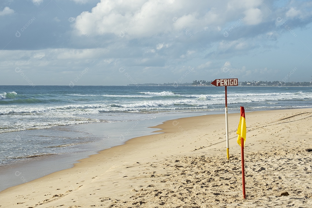 sinal na areia da praia indicando perigo escrito em português