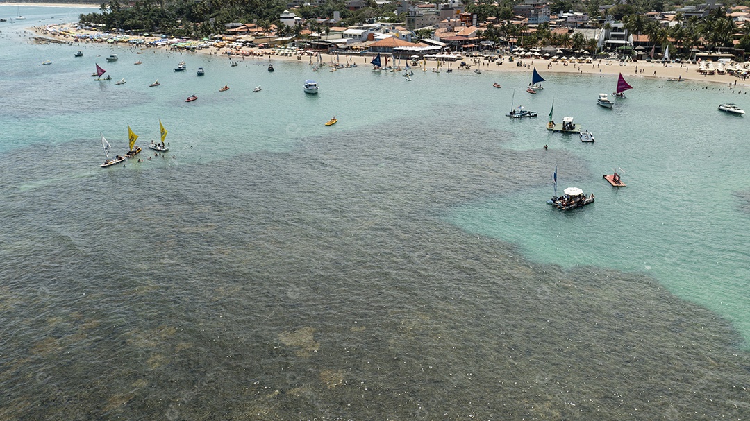 Turistas e pequenos barcos em piscinas naturais