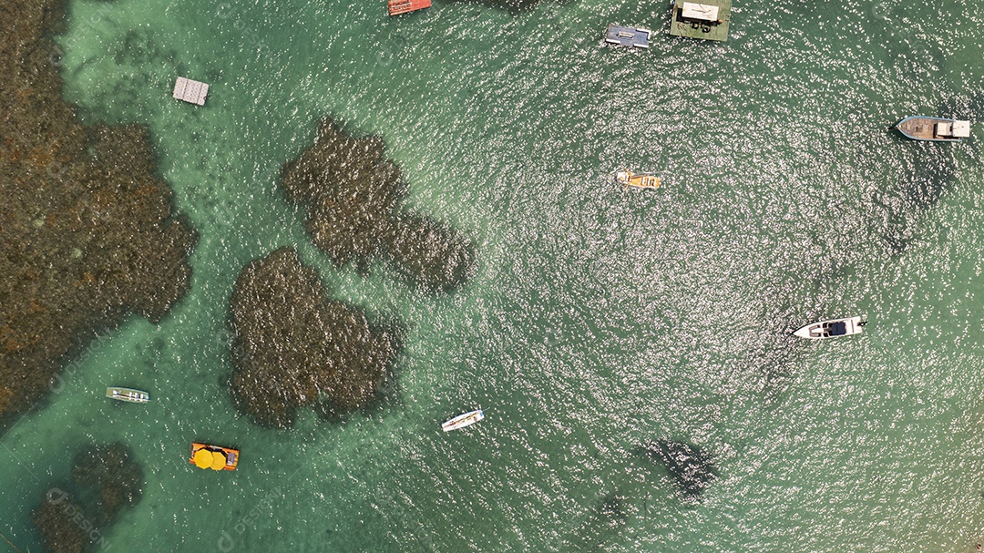 vista superior de pequenas embarcações em piscinas naturais formadas por arrecifes