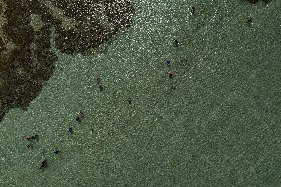 vista de cima dos turistas em piscina natural formada por arrecifes