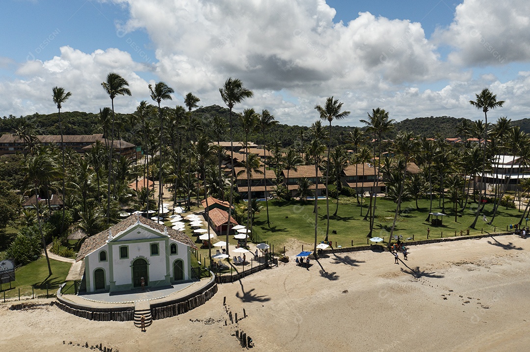 Igreja com coqueiros ao fundo e turistas à frente