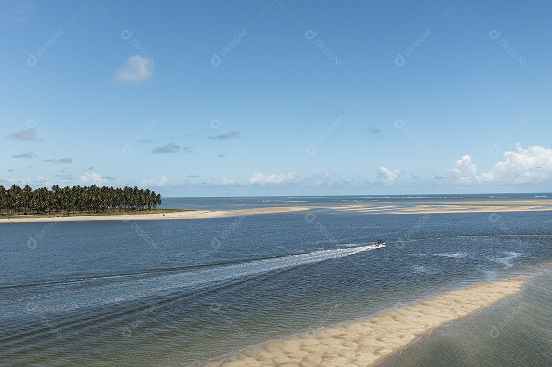 Pequeno barco navegando no local onde o rio encontra o mar