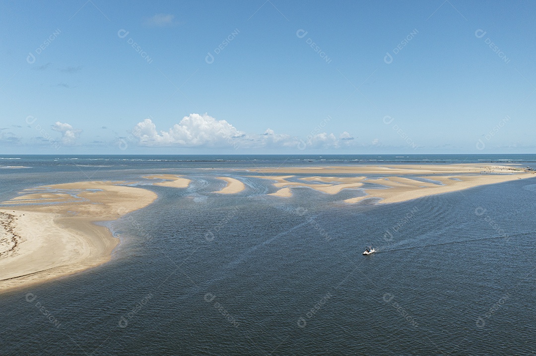 Pequeno barco navegando no local onde o rio encontra o mar