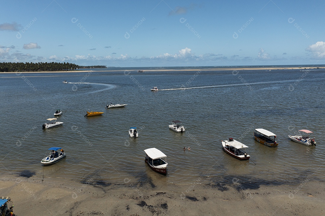 Pequenos barcos atracados no local onde o rio encontra o mar