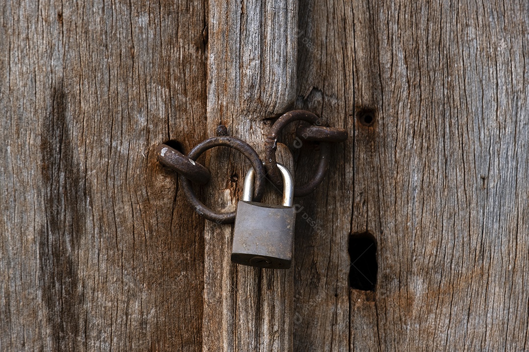 cadeado antigo com corrente trancando porta de madeira velha