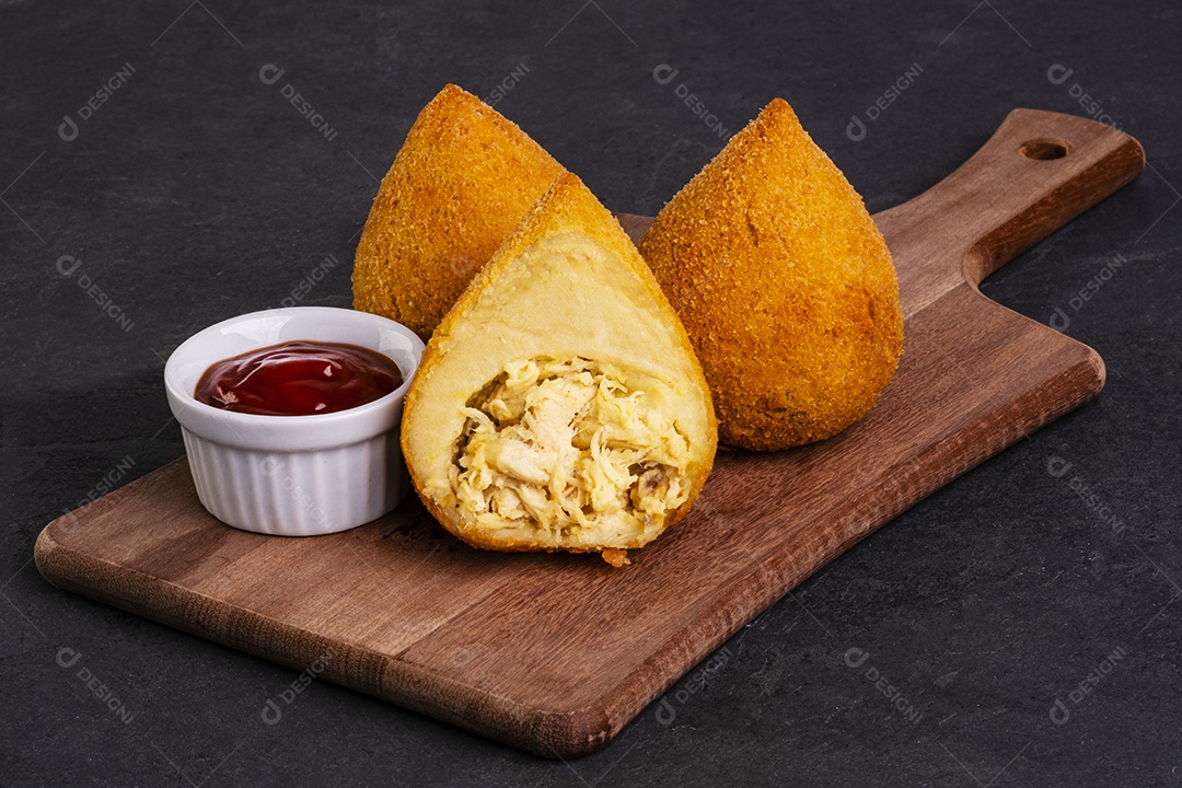 tradicional coxinha frita em tábua de madeira sobre pedra ardósia