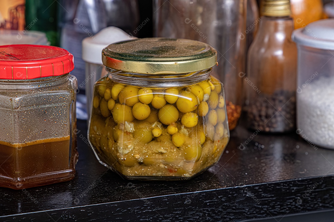 Pote de vidro com tampa dourada com jurubeba em conserva dentro.