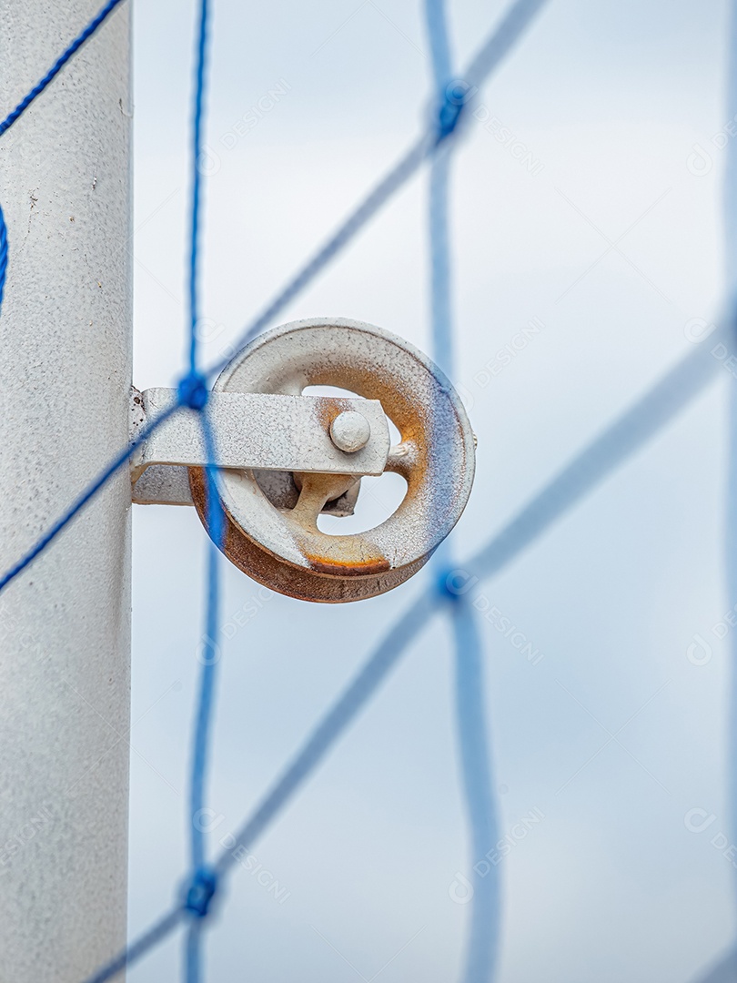 Polia em um poste de metal para estender rede na quadra de vôlei.