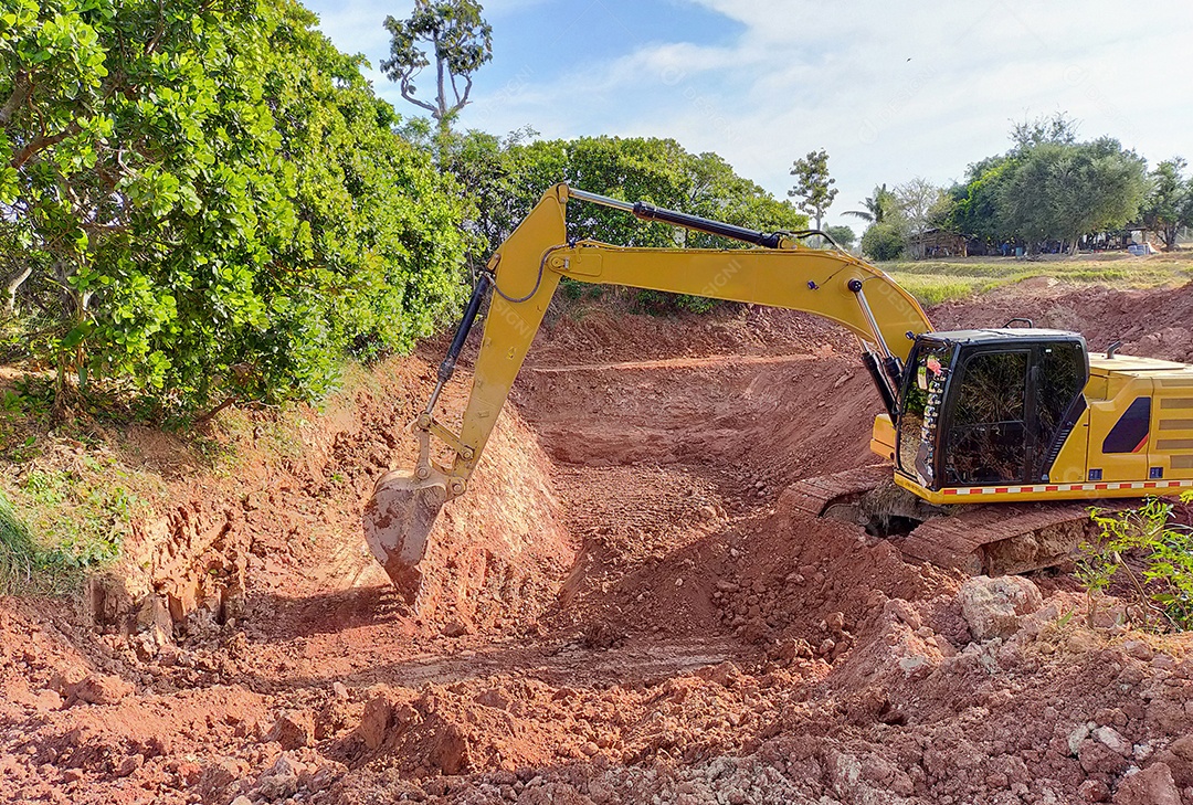 Balde de retroescavadeira cavando o solo na fazenda agrícola para fazer lagoa