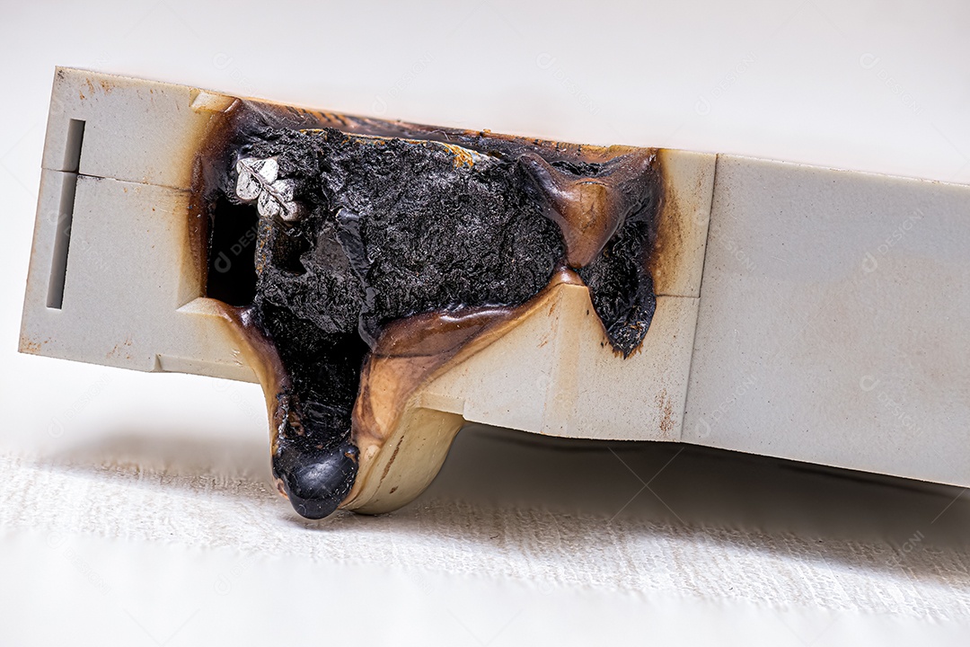 Fotografia macro de um disjuntor elétrico queimado com plástico derretido