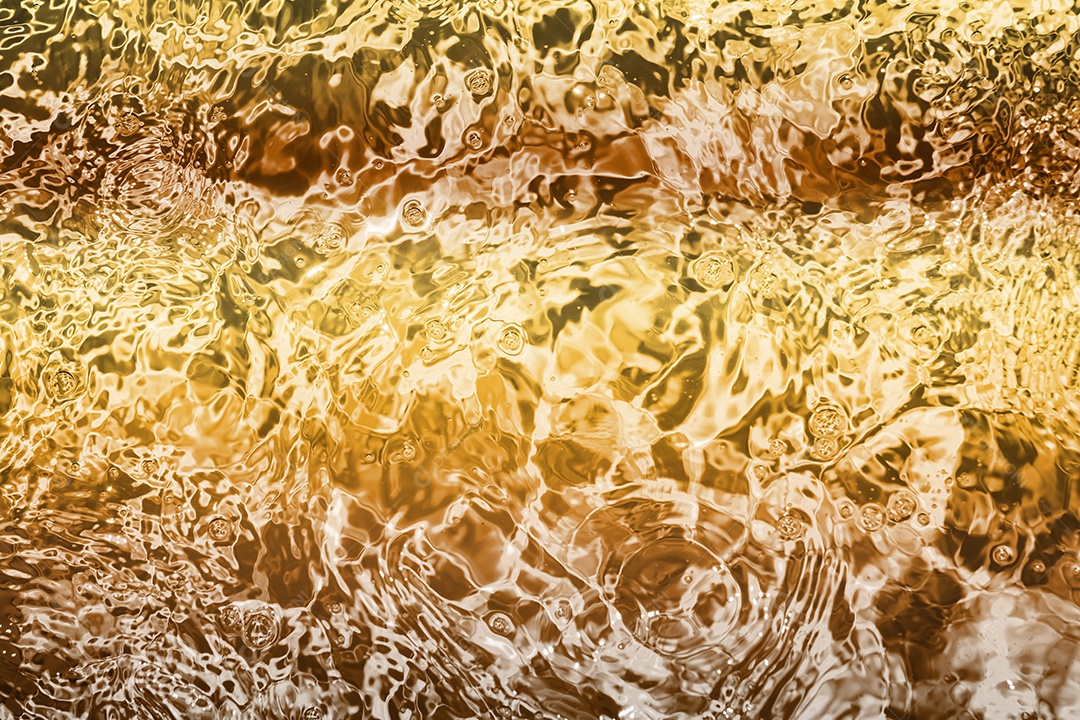 Textura de superfície de água calma transparente turva cor de ouro amarelo claro com salpicos e bolhas. Fundo de natureza abstrata na moda. Ondas de água na luz solar. fundo de água, óleo