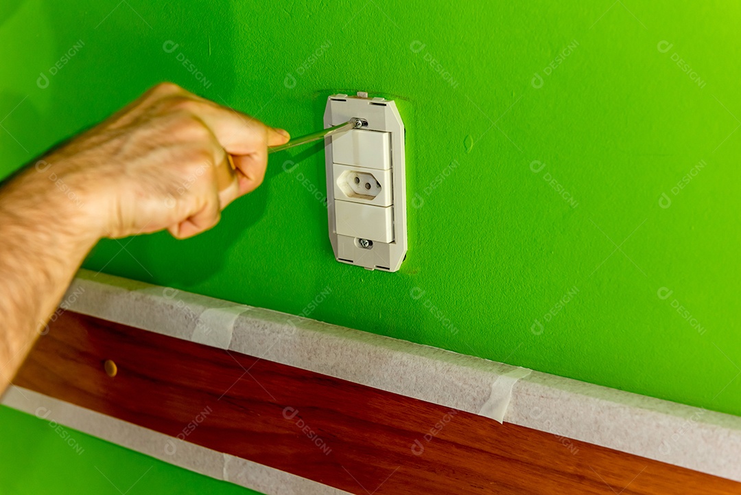 Mãos de eletricista apertando em soquetes