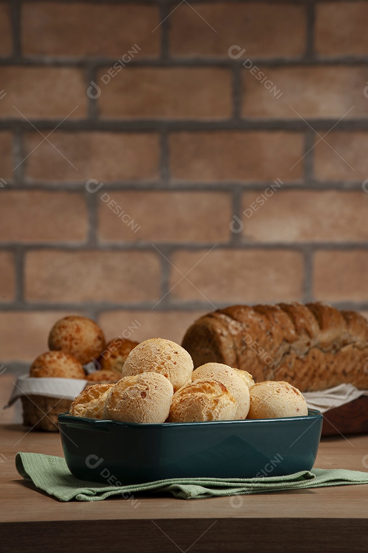 Pão integral com pães de queijo na cesta atrás.