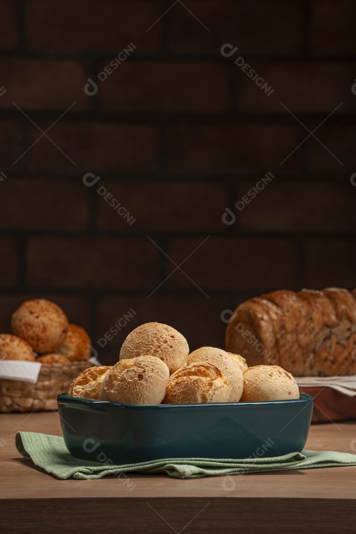 Pão integral com pães de queijo na cesta atrás.