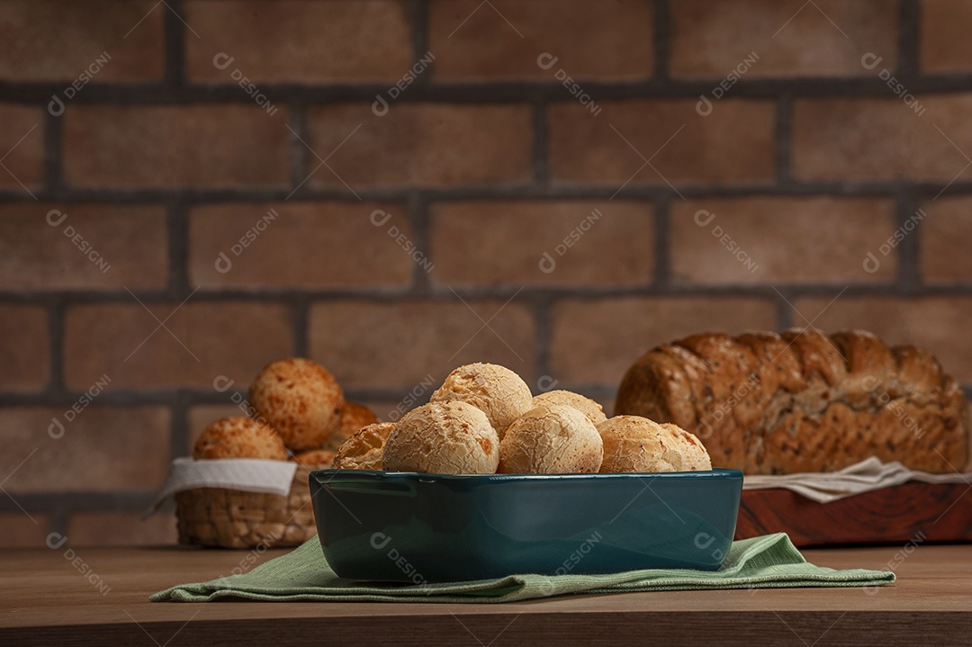 Pão integral com pães de queijo na cesta atrás.