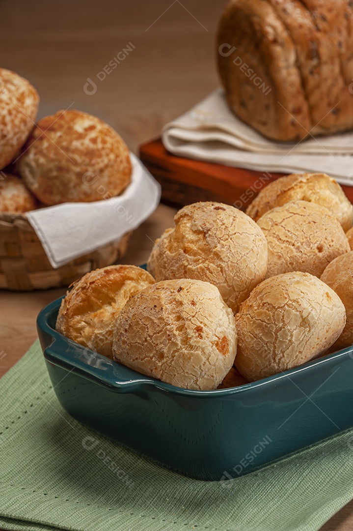 Pão integral com pães de queijo na cesta atrás.