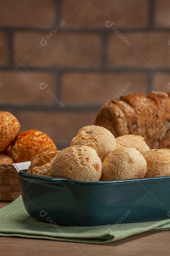 Pão integral com pães de queijo na cesta atrás.