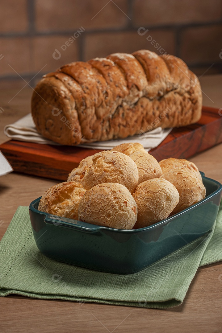 Pão integral com pães de queijo na cesta atrás.