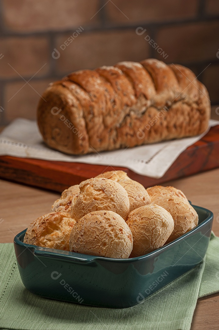 Pão integral com pães de queijo na cesta atrás.