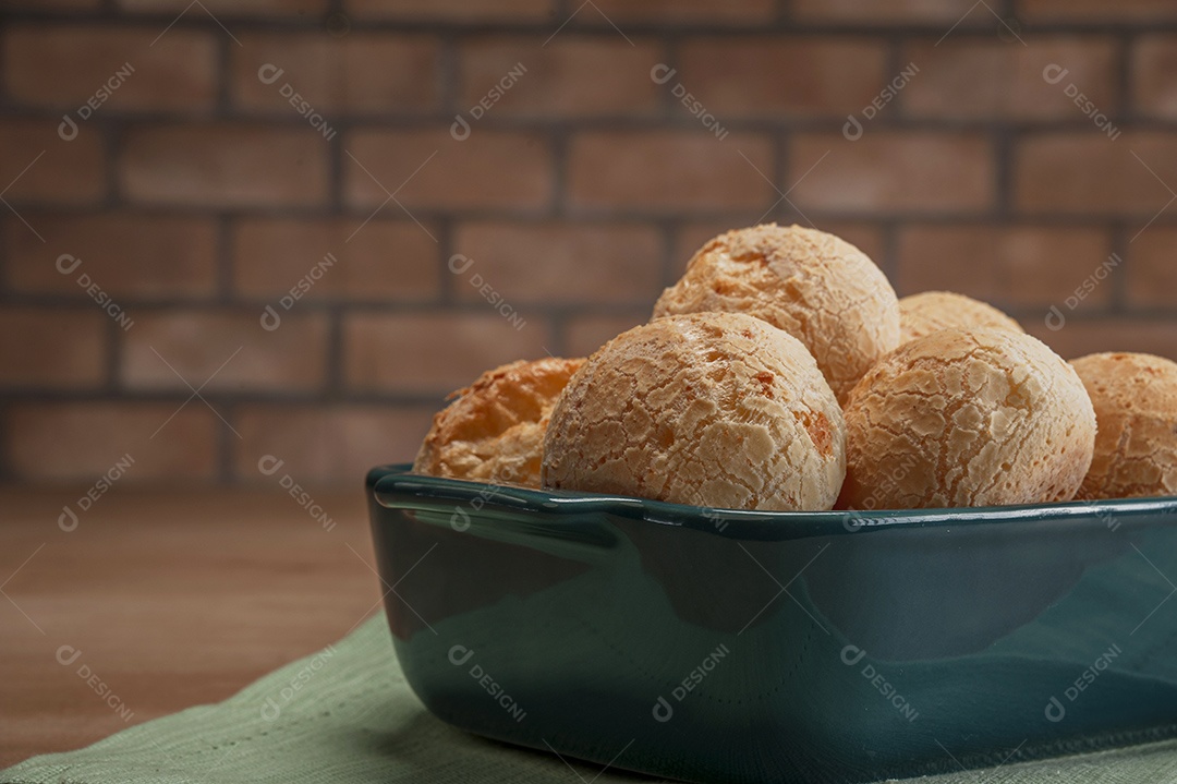 Pão integral com pães de queijo na cesta atrás.