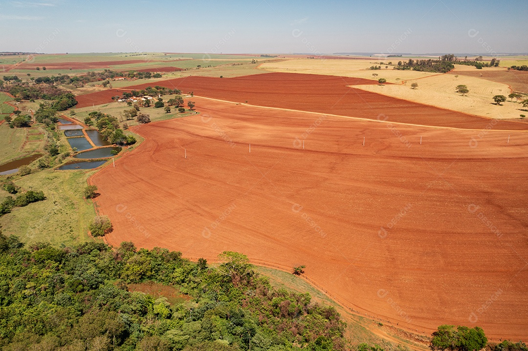 cativeiro de peixes ao lado da terra pronta para plantio