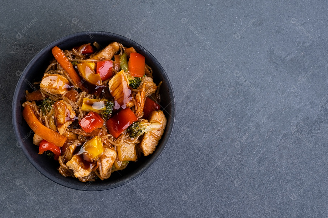 yakissoba de frango em tigela de cerâmica preta - vista superior.