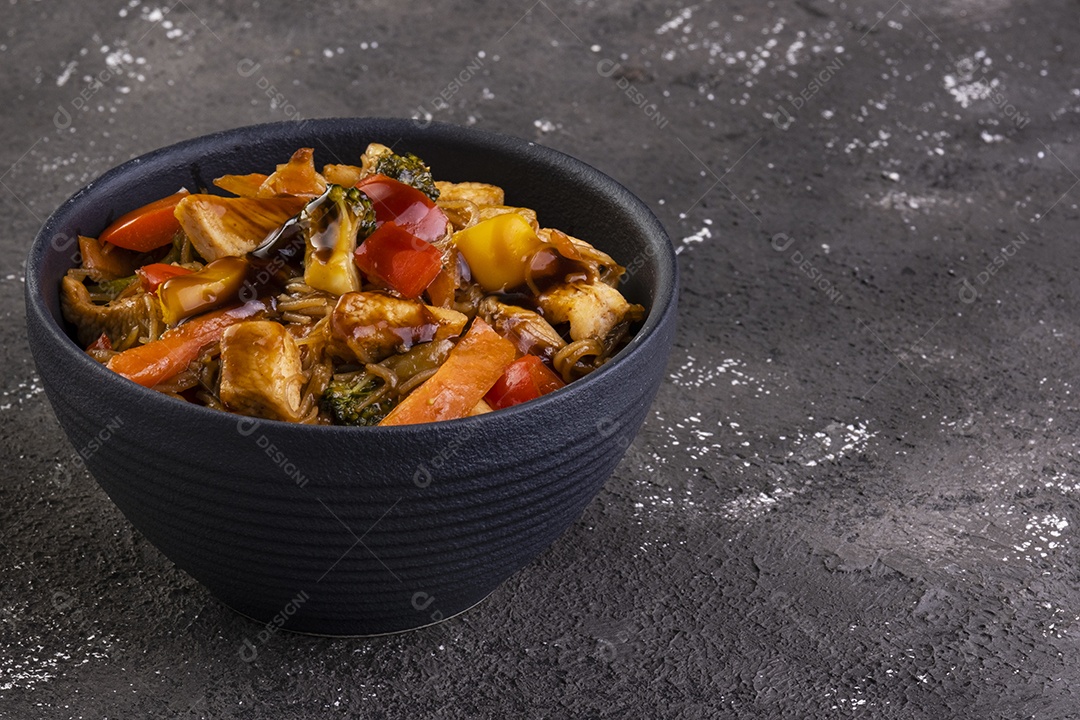 yakissoba de frango em tigela de cerâmica preta.