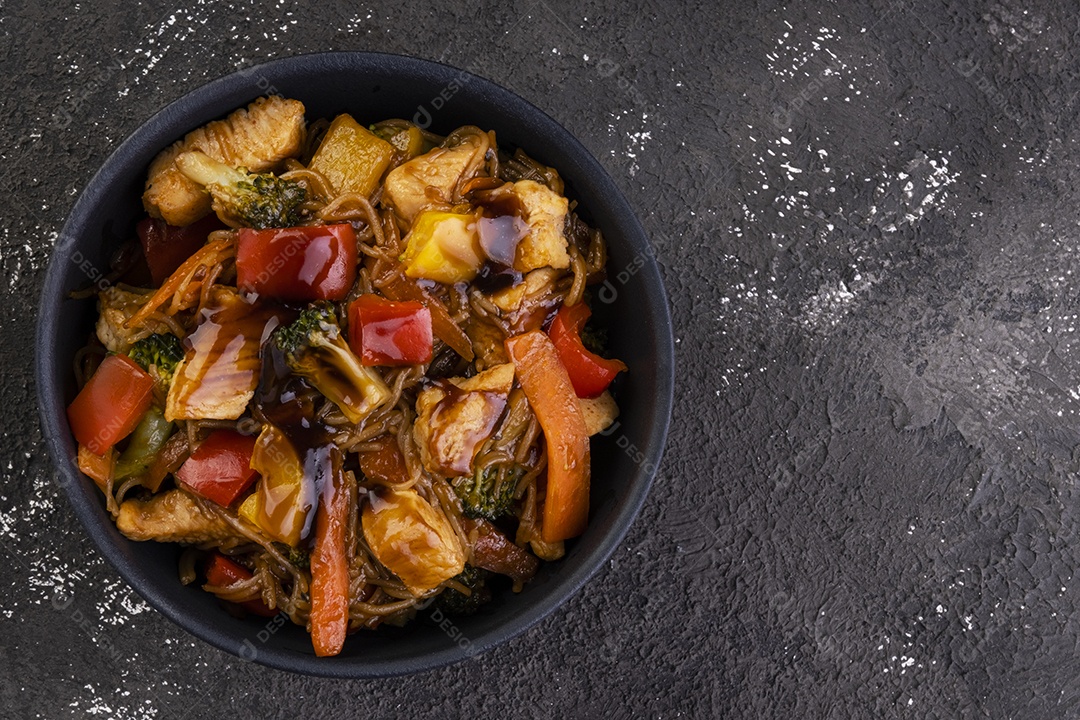 yakissoba de frango em tigela de cerâmica preta - vista superior.