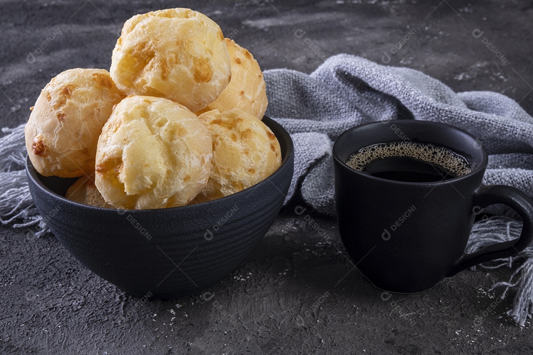 Deliciosos pães de queijo e uma caneca de café em fundo escuro