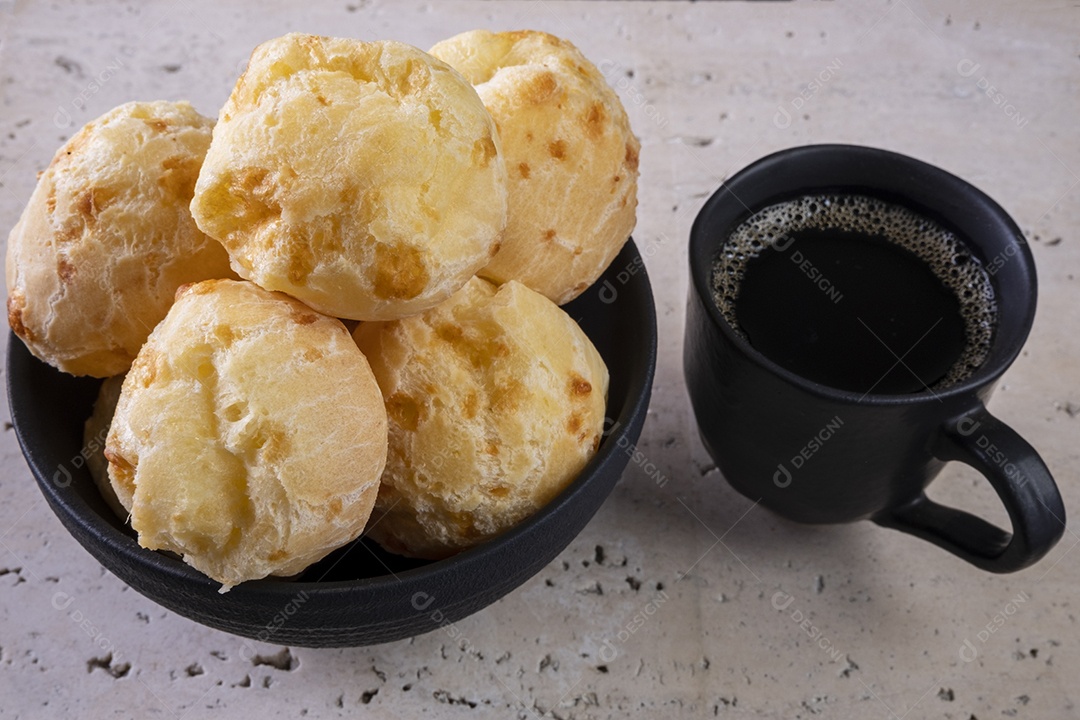 Deliciosos pães de queijo e uma xícara de café em mármore branco