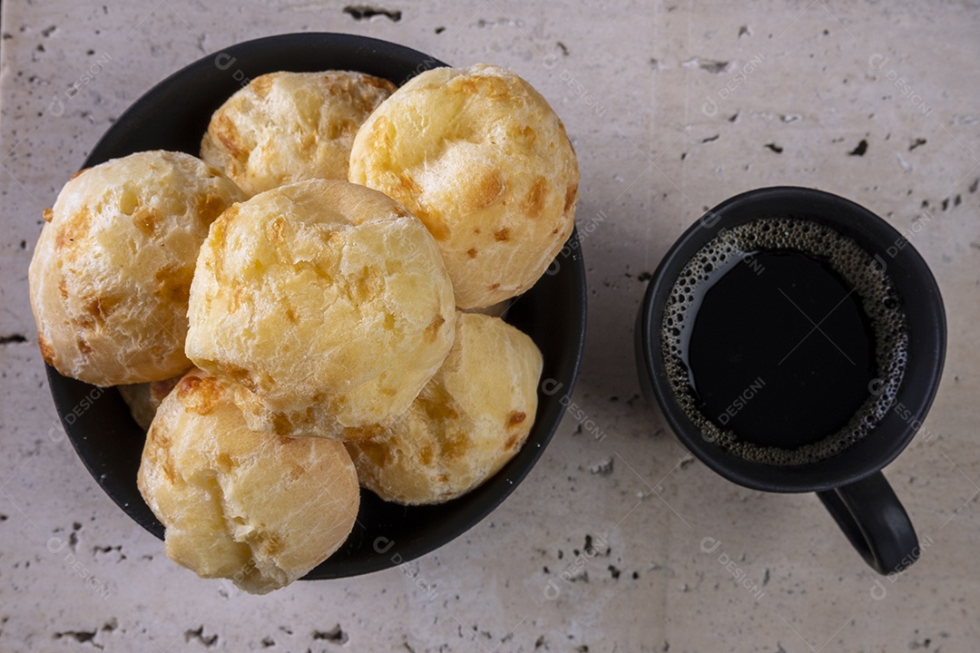 Deliciosos pães de queijo e uma xícara de café em mármore branco