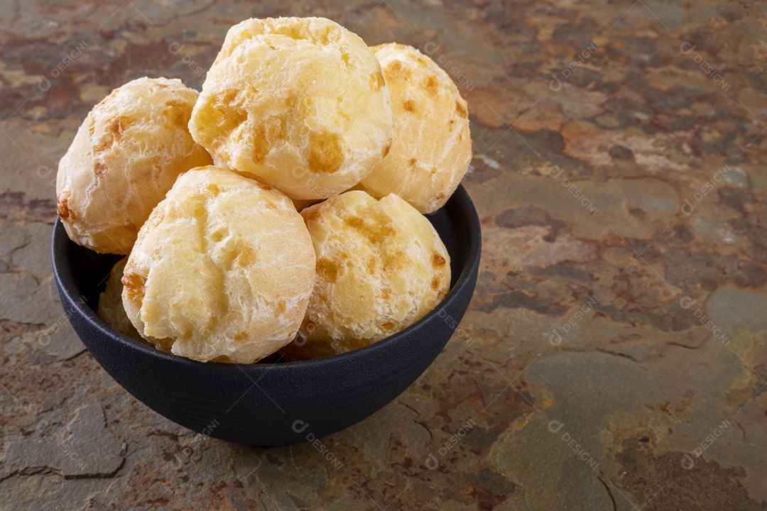 Tigela de pães de queijo em uma pedra de ardósia enferrujada
