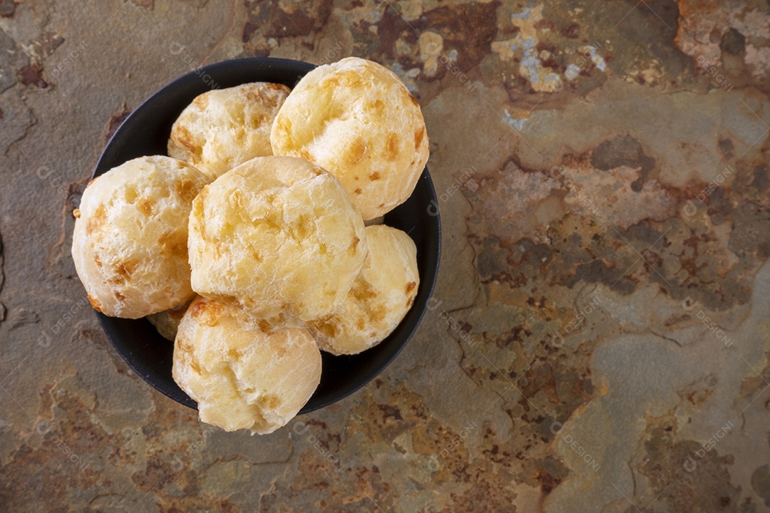 Tigela de pães de queijo em uma pedra de ardósia enferrujada