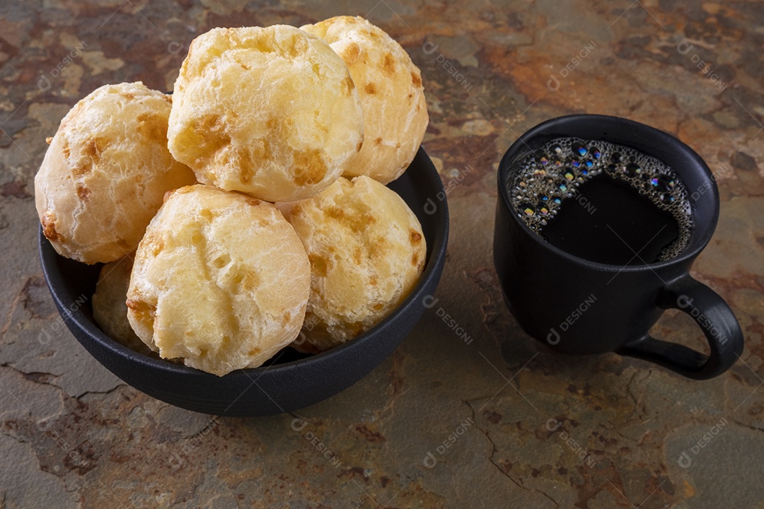 Deliciosos pães de queijo e uma xícara de café em ardósia enferrujada